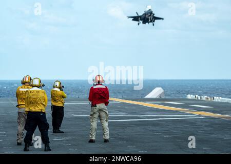 OKINAWA, Japon (12 janvier 2023) des marins affectés au porte-avions amphibie déployé à l'avant USS America (LHA 6) observent un F-35B Lightning II de l'Escadron d'attaque de chasseurs marins (VMFA) 242 alors qu'il approche du pont de vol du navire tout en étant en cours dans les environs d'Okinawa, au Japon, le 12 janvier. L'Amérique, navire chef de file du America Amphiobie Ready Group, opère dans la zone d'opérations 7th de la flotte pour améliorer l'interopérabilité avec ses alliés et ses partenaires et servir de force de réaction prête à l'emploi pour défendre la paix et la stabilité dans la région Indo-Pacifique. Banque D'Images