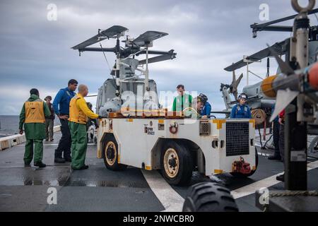 OCÉAN PACIFIQUE NORD (23 janvier 2023) - des marins affectés au navire de quai de transport amphibie USS Green Bay (LPD 20) transportent un hélicoptère UH-1Y Huey du Marine Medium Tiltrotor Squadron (VMM) 262 sur le pont de vol du navire. Green Bay opère dans la zone d'exploitation de la flotte 7th. 7th Fleet est le U.S. La plus grande flotte numérotée déployée à l’avant de la Marine interagit et opère régulièrement avec ses alliés et partenaires pour préserver une région libre et ouverte de l’Indo-Pacifique. Banque D'Images