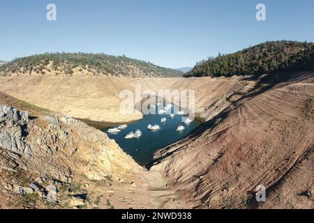 Les Péniche se trouvent dans des eaux peu profondes sur le lac Oroville, l'un des plus grands réservoirs de Californie, alors que les niveaux des lacs plongent à des niveaux records, à 200 pieds au-dessous de la normale. Banque D'Images