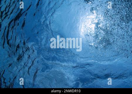 Fermer photo de beaucoup de belles bulles d'air sous-marin montent à travers l'eau de mer bleue de respiration ascendante conducteur, gros plan photo. Lumière du soleil Banque D'Images