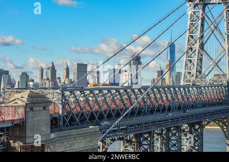 Gros plan sur un pont à Manhattan, New York, lors d'une belle journée de ciel bleu en hiver, avec le soleil qui brille sur le paysage de la ville en arrière-plan. Banque D'Images