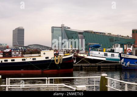 Musée des sciences NEMO à travers Oosterdock, Amsterdam, pays-Bas, avec des barges et des bateaux au premier plan Banque D'Images