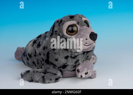 Mère et bébé Harbour Seal animaux en peluche sur un fond bleu et blanc sans couture. Banque D'Images