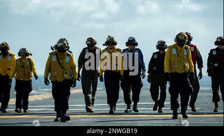 OKINAWA, Japon (12 janvier 2023) des marins affectés au porte-avions amphibie déployé à l'avant USS America (LHA 6) et des Marines affectés au Marine Fighter Attack Squadron (VMFA) 242 effectuent une promenade sur le pont de vol du navire en cours dans les environs d'Okinawa, au Japon, le 12 janvier. L'Amérique, navire chef de file du America Amphiobie Ready Group, opère dans la zone d'opérations 7th de la flotte pour améliorer l'interopérabilité avec ses alliés et ses partenaires et servir de force de réaction prête à l'emploi pour défendre la paix et la stabilité dans la région Indo-Pacifique. Banque D'Images