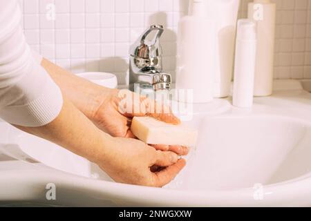 Elle se lave les mains avec du savon dans la salle de bains. Hygiène et santé propreté et soins du corps Banque D'Images