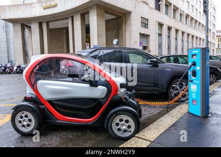 Milan, Italie, 27 février 2023. Une microvoiture électrique Renault Twizy est chargée par temps de pluie à une station de charge A2A dans une rue du centre de Milan. Banque D'Images