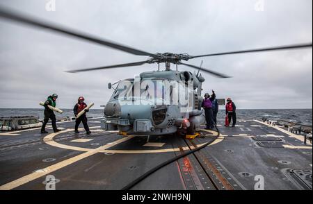 MER BALTIQUE (24 janvier 2023) les marins transportent des bouées sonar et effectuent un ravitaillement en pompe à chaud à bord d'un hélicoptère MH-60R Seahawk, attaché à l'escadron de frappe maritime (HSM) 79, sur le pont de vol du destroyer à missiles guidés de la classe Arleigh Burke USS Roosevelt (DDG 80), le 24 janvier 2023. Roosevelt est en cours de déploiement aux États-Unis Marine Forces Europe zone d'opérations, employée par les États-Unis Sixième flotte pour défendre les intérêts des États-Unis, des alliés et des partenaires. Banque D'Images