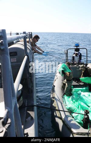 230106-N-NO146-1002 GOLFE D'OMAN (le 6 janvier 2023) des marins du navire de patrouille côtière USS Chinook (PC 9) transfèrent des armes saisies d'un navire de pêche dans les eaux internationales du golfe d'Oman, le 6 janvier. Les forces navales américaines ont saisi 2 116 fusils d'assaut AK-47 d'un navire de pêche qui transitait le long d'une route maritime entre l'Iran et le Yémen. Banque D'Images