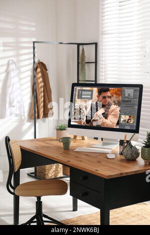 Le lieu de travail du concepteur. Ordinateur avec application d'édition de photos sur table à l'intérieur Banque D'Images