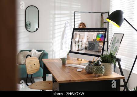 Le lieu de travail du concepteur. Ordinateur avec application d'édition de photos sur table à l'intérieur Banque D'Images