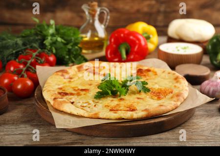 Délicieux khachapuri avec du fromage sur une table en bois Banque D'Images