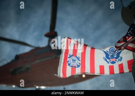A ÉTATS-UNIS L'hélicoptère Dolphin de la Garde côtière Eurocopter MH-65 de la station aérienne Savannah survole un drapeau de la Garde côtière lors de l'entraînement des opérations d'hélicoptère à Charleston Harbour, Caroline du Sud, le 5 janvier 2023. L'équipage s'entraîne régulièrement pour les opérations de levage au cas où une évacuation médicale réelle serait nécessaire. Banque D'Images
