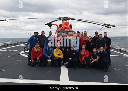 L'équipage du USCGC Stone (WMSL 758) pose une photo après avoir entraîné des évolutions avec un équipage d'hélicoptère MH-65 Dolphin de l'escadron tactique d'interception d'hélicoptères de la Garde côtière dans l'océan Atlantique, le 14 janvier 2023. Stone est en cours de déploiement de plusieurs missions dans l'Atlantique Sud pour contrer les activités maritimes illicites et renforcer les relations de souveraineté maritime dans l'ensemble de la région. Banque D'Images