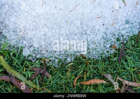 Une pile de petites pierres de grêle sur l'herbe. Banque D'Images