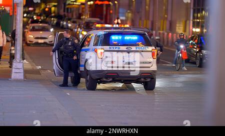 Les policiers s'éboulent d'une voiture de police NYPD à Manhattan - NEW YORK CITY, USA - le 14 FÉVRIER 2023 Banque D'Images