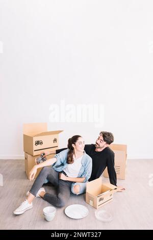 Couple s'appuyant contre les boîtes mobiles Banque D'Images