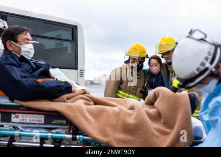 ÉTATS-UNIS Les spécialistes du corps maritime de sauvetage et de lutte contre les incendies d'aéronefs (ARFF) affectés à l'Escadron de soutien de l'escadre Marine (SMSS) 171, Groupe d'aéronefs marins (MAG) 12, observent le transport d'une victime simulée lors d'une formation d'intervention d'urgence au MCAS Iwakuni, au Japon, le 10 février 2023. Cette formation est une exigence annuelle pour les Marines ARFF dans laquelle ils et le personnel des services d'incendie et d'urgence de la ville d'Iwakuni coopèrent pour améliorer la préparation et l'efficacité lors de la réponse aux incidents de victimes de masse sur la base en vue de scénarios potentiels dans le monde réel. Banque D'Images