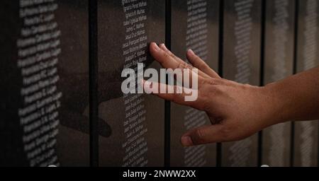 Un membre de la famille Chamorro touche les noms des membres de la famille, qui ont servi dans l'armée américaine pendant la Seconde Guerre mondiale, au parc historique national, Asan Bay Overlook, Asan, Guam, le 17 janvier, 2023. Dans la baie d’Asan, des fournitures et du matériel ont été chargés sur des navires pour soutenir la campagne américaine de saut d’île vers l’île du Japon où de nombreux membres de service sont morts, en 1944. Aujourd’hui, la présence militaire à Guam joue un rôle essentiel dans l’objectif de 38th du Commandant de la Force Design de 2030 du corps des Marines de transférer la mission du corps des Marines vers l’Indo-Pacifique. Banque D'Images