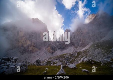 Le sommet de l'aiguille de pierre Campanile Basso à Brenta Dolomites au milieu des falaises rocheuses environnantes, partiellement couvertes de nuages. Banque D'Images