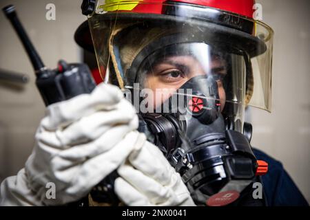 Le technicien d'entretien de la coque 3rd classe Naomi Nanez, affecté au navire de transport amphibie de classe San Antonio USS Arlington (LPD 24), utilise une radio pour communiquer avec un casier de réparation lors d'un exercice de construction de quartiers généraux en cours dans l'océan Atlantique, le 10 février 2023. Les marins d'Arlington maintiennent la maîtrise des dommages en effectuant des exercices de routine à la fois à l'intérieur et en cours. Banque D'Images