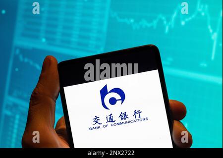 Chine. 19th févr. 2023. Dans cette illustration, le logo de la Banque chinoise de communications est affiché sur un smartphone avec un graphique de l'indice boursier économique en arrière-plan. Crédit : SOPA Images Limited/Alamy Live News Banque D'Images