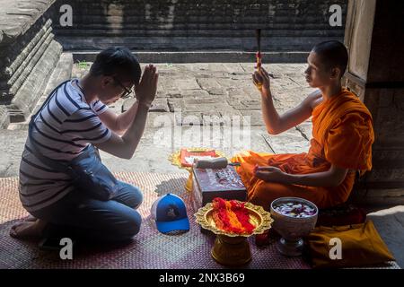 Monk blessing a man, in Angkor Wat, Siem Reap, Cambodia Stock Photo