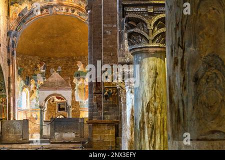 Les allées latérales de la basilique San Pietro en Tuscania contiennent deux ciboria et les fresques racontent l'histoire du Christ, des Apôtres et du Baptist. Banque D'Images