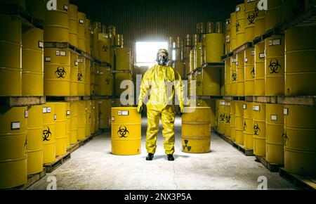 stockage des déchets toxiques et de l'homme en fûts métalliques dans une combinaison de protection jaune Banque D'Images