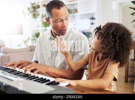 Piano, apprentissage et fille avec grand-père à la maison, jouer ou se lier ensemble. Wow surprise, l'éducation et choqué grand-père enseignant comment jouer Banque D'Images