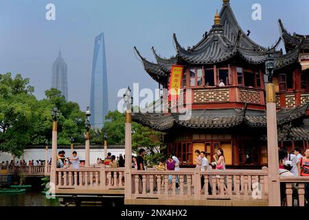 Chine.Shanghai : Yu Yuan Bazar. Pont en zigzag et maison de thé Huxinting à droite. L'horizon de Pudong en arrière-plan avec Jin Mao Building et Shanghai World Banque D'Images