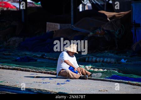 01/03/2023 les pêcheurs de la flotte de pêche Caleta de Velez près de Torre del Mar, Malaga, Espagne réparent leurs filets. Banque D'Images