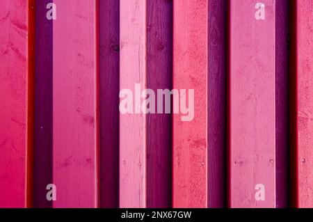 Arrière-plan en bois texturé. Gros plan de planches en bois. Couleurs : rouge, rose et violet. Banque D'Images