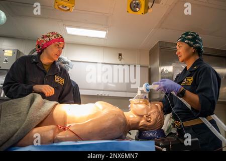 Cmdr. Amy Hernandez, chirurgien général de Fleet Surgical Team (FST) 1, à gauche, et Cmdr. Kim Gerber, infirmière anesthésiste agréée certifiée FST 1, effectue une intervention chirurgicale sur un mannequin lors d'une intervention en cas de sinistre avec des marins du porte-avions nucléaire USS Nimitz (CVN 68), à bord du navire d'assaut amphibie USS Makin Island (LHD 8), le 11 février 2023 en mer de Chine méridionale. Le Nimitz Carrier Strike Group (NIMCSG) et le navire d'assaut amphibie USS Makin Island (LHD 8) avec l'unité expéditionnaire maritime 13th embarqué mènent des opérations de la force expéditionnaire conjointe (ESF), représentant le HHI unique Banque D'Images