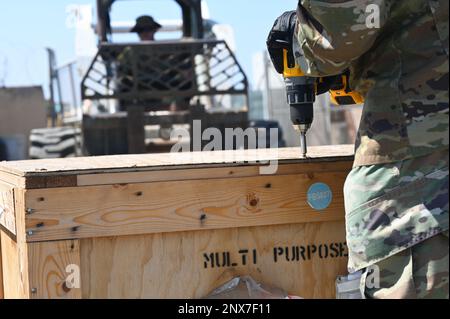 A ÉTATS-UNIS Spécialiste de la gestion du matériel de la Force aérienne au sein de l’Escadron de la base aérienne expéditionnaire (EABS) de 726th, ferme une caisse de cargaison alors qu’un chariot élévateur attend de la charger au Camp Lemonnier, à Djibouti, le 7 février 2023. Les spécialistes de l'approvisionnement de l'EABS de 726th sont non seulement responsables du Camp Lemonnier, mais aussi d'autres endroits de la zone de responsabilité de l'Afrique orientale. Banque D'Images