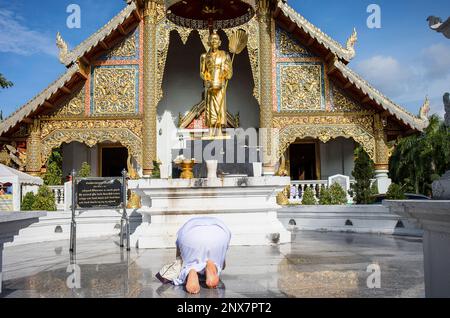 Femme priant, au temple de Wat Phra Singh, Chiang Mai, Thaïlande Banque D'Images
