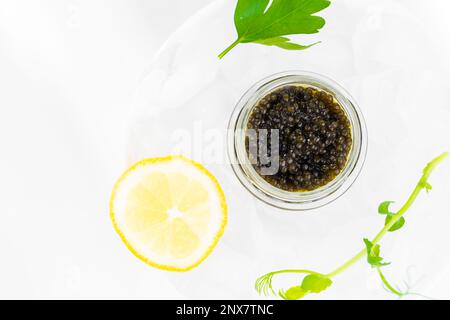 Hors-d'œuvre de délicieux mets délicats, caviar noir d'esturgeon naturel, tranche de citron, persil dans un cube de glace. Mise au point sélective Banque D'Images