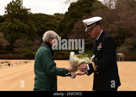 YOKOHAMA, Japon (14 février 2023) Lt. j.g. Nicolas Tobin, États-Unis L'aumônier d'état-major de la Marine, affecté au commandant des activités de la flotte Yokosuka, remet des fleurs à un membre de la famille vétéran lors d'une cérémonie commémorative de guerre pour le programme d'amitié des Japonais/prisonniers de guerre, le 14 février, au cimetière de guerre du Commonwealth de Yokohama. Le cimetière comprend une importante urne contenant les cendres de 335 marins, soldats et aviateurs des États-Unis, du Commonwealth britannique et du Royaume des pays-Bas, qui sont morts comme prisonniers de guerre au Japon. La cérémonie est parrainée par le ministère japonais des Affaires étrangères et commandant de la Marine Banque D'Images