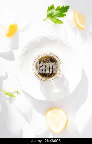 Hors-d'œuvre de délicieux mets délicats, caviar noir d'esturgeon naturel, tranche de citron, persil dans un cube de glace. Mise au point sélective Banque D'Images