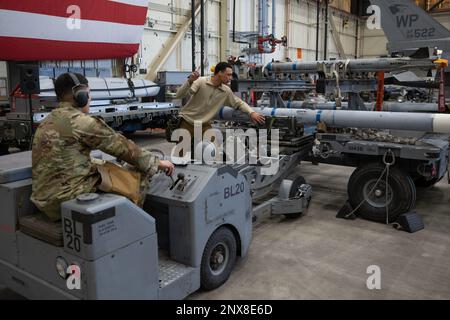 L’aviateur Julio Valle (à gauche), membre de l’équipage de chargement de l’escadron de production de chasseurs 80th, suit le sergent d’état-major Elijah Nolan’s, chef de l’équipage de chargement de FGS 80th, guide sur le retrait d’un missile-120 intercepté par voie aérienne d’une remorque d’unité de manutention de munitions à la base aérienne de Kunsan, République de Corée, le 27 janvier 2023. L'objectif principal de la compétition d'équipage de charge du trimestre 4th était d'être l'équipe la plus rapide pour charger des munitions sur un faucon de combat F-16. Banque D'Images