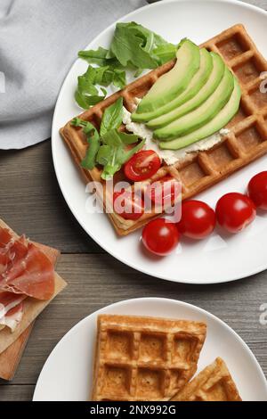 Gaufres belges fraîches avec avocat, tomates et arugula sur une table en bois, plat Banque D'Images