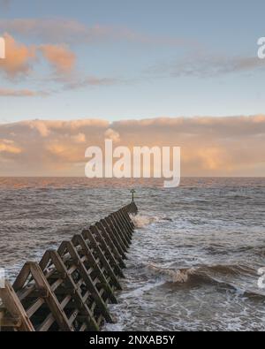 Walton sur le coucher du soleil de Naze. Vue sur les disjoncteurs. Tons chauds du soleil couchant. Les vagues se brisent. Une journée venteuse. Banque D'Images