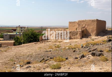 Ancienne maison en adobe et bâtiments modernes à proximité. Une maison en adobe, qui a été fréquemment utilisée en Anatolie dans le passé récent. Kilis, Turquie. Banque D'Images