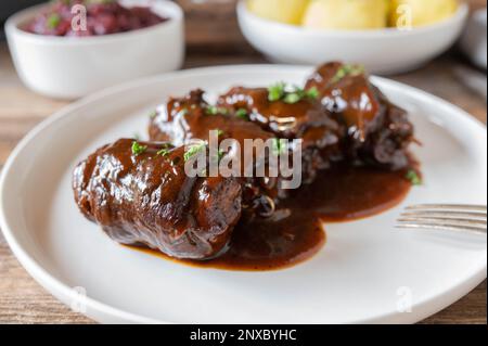 Roulés de bœuf avec une délicieuse sauce brune. Plat de viande allemand traditionnel avec chou rouge et boulettes de pommes de terre Banque D'Images