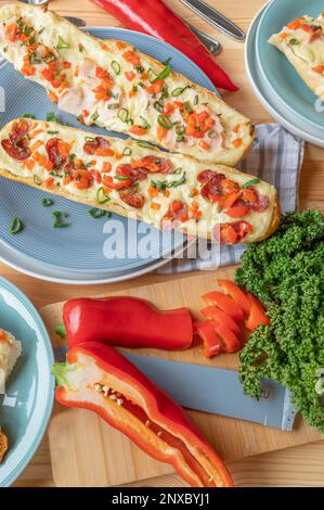 Sandwichs à la baguette avec salami, jambon et fromage. Nappés de poivrons rouges et de ciboulette Banque D'Images