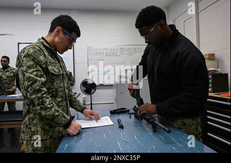 GREAT LAKES, Ill. (1 février 2023) Jesus A. ReyesRomero, à gauche, a lu les instructions techniques comme l'apprenti Anthony O. Williams, deux étudiants du Commandement de l'entraînement des systèmes de combat de surface des Grands Lacs, assemble une carbine M4 à l'école 'A' Gunner's Mate (GM). L’école « A » de GM offre aux marins candidats une formation technique sur l’entretien des armes, l’électricité, l’électronique et le fonctionnement des systèmes de lancement et des torpilles. Banque D'Images