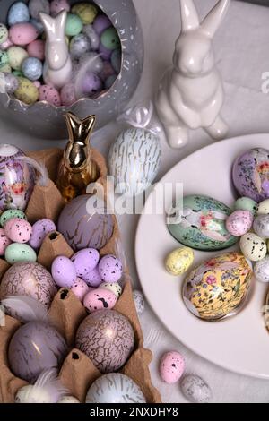 photo des oeufs décoratifs de différentes formes et couleurs et un lapin sur la table Banque D'Images