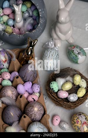 photo d'oeufs peints couchés sur la table avec un lapin en céramique blanc à côté d'eux Banque D'Images