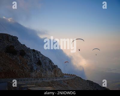 Parapente dans le ciel. Tandem de parapente volant au-dessus de la mer et des montagnes par jour nuageux. Vue sur le parapente et le lagon bleu à Oludeniz, Turquie. Sport extrême. Paysage Banque D'Images