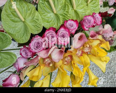 arrangement floral de nénuphars, de rose et d'orchidée jaune Banque D'Images