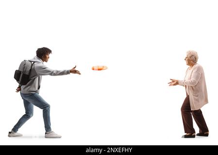 Photo pleine longueur d'un jeune afro-américain qui lance un disque volant avec une femme âgée isolée sur fond blanc Banque D'Images